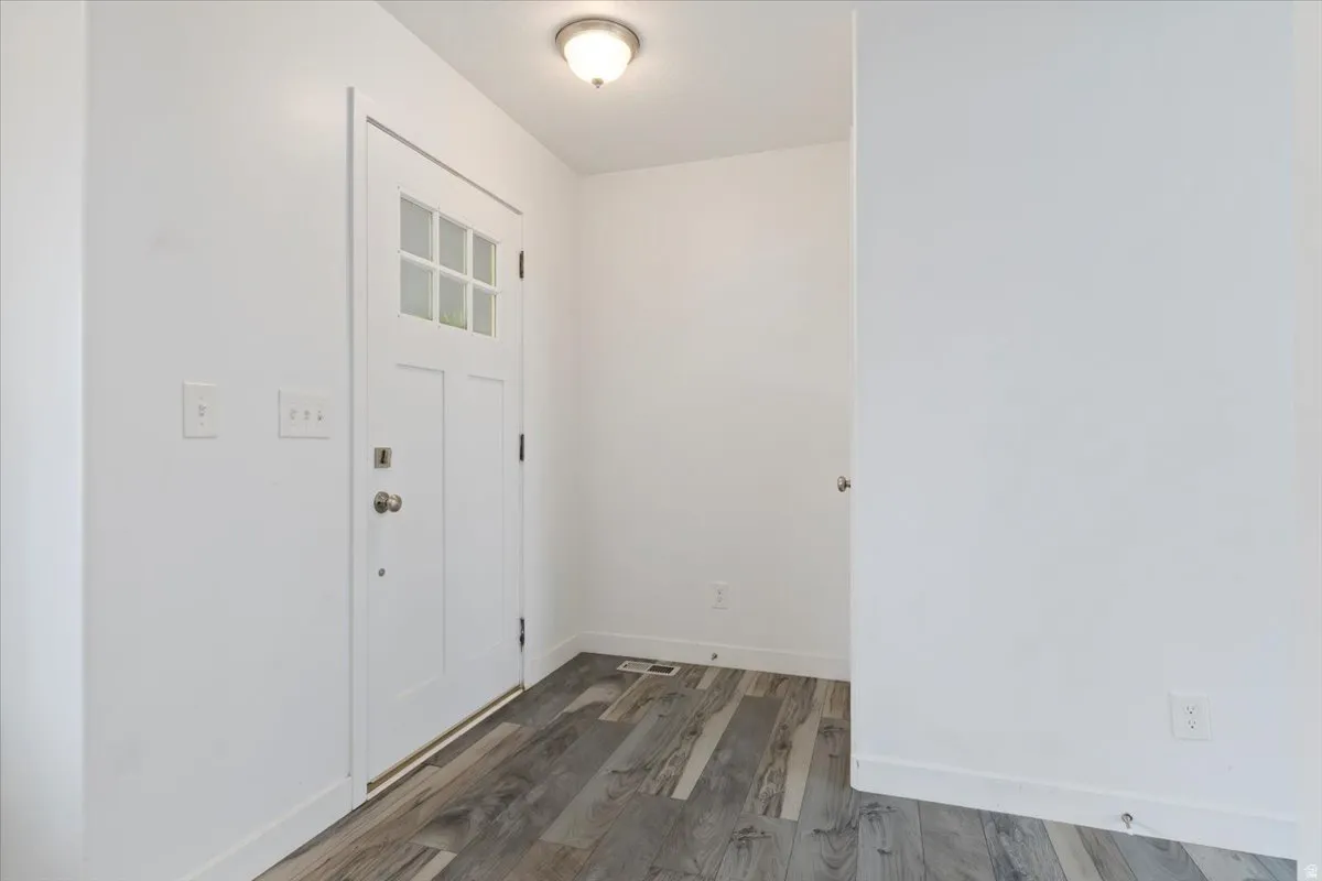 Entryway featuring a white paneled door with glass inserts, wood-finish flooring, and a flush mount ceiling light