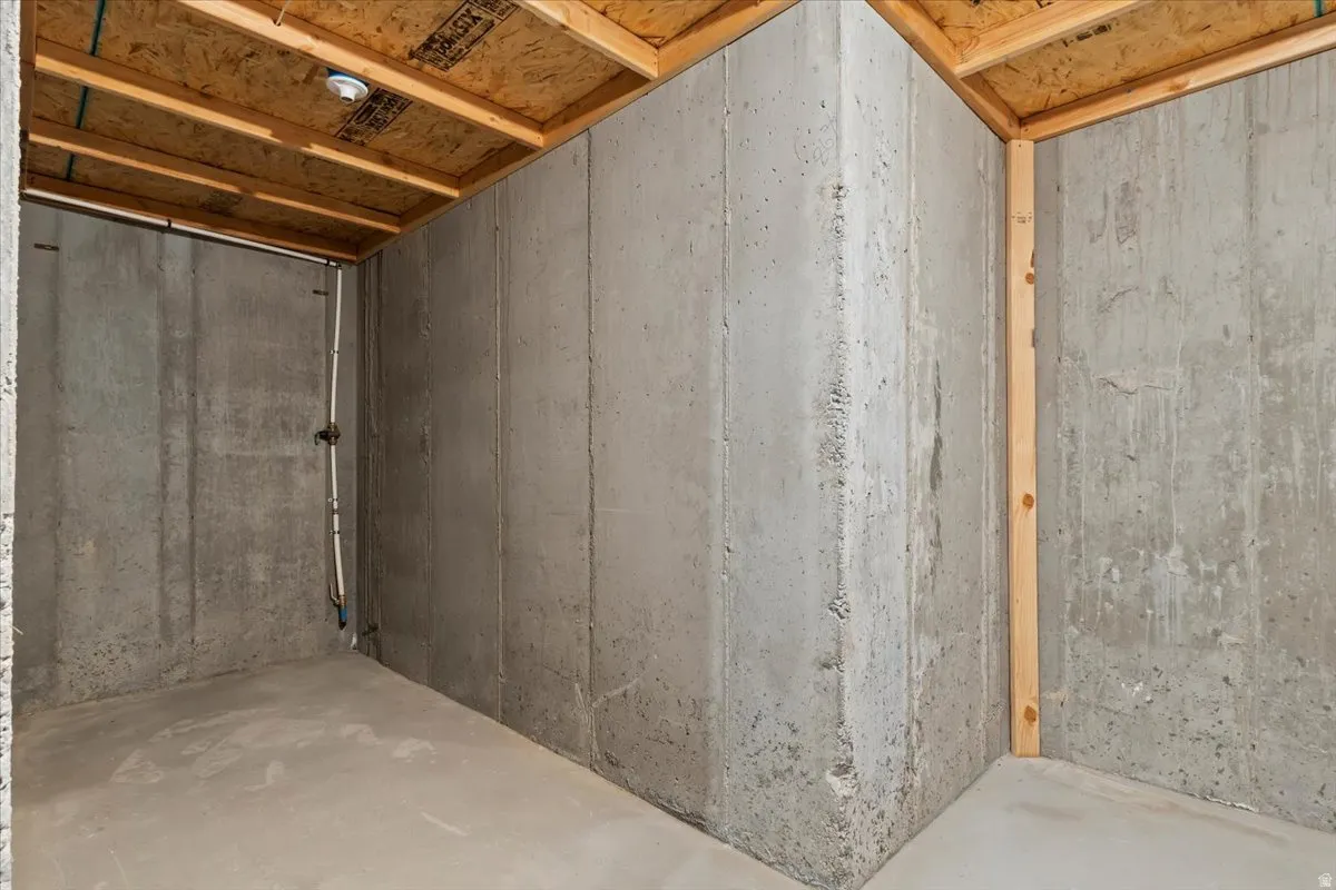 Concrete foundation walls with exposed wood joists and subflooring