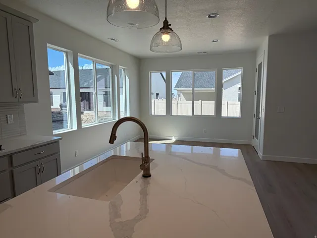 Extended island with gooseneck touch faucet, high level quartz countertops and single bowl composite kitchen sink