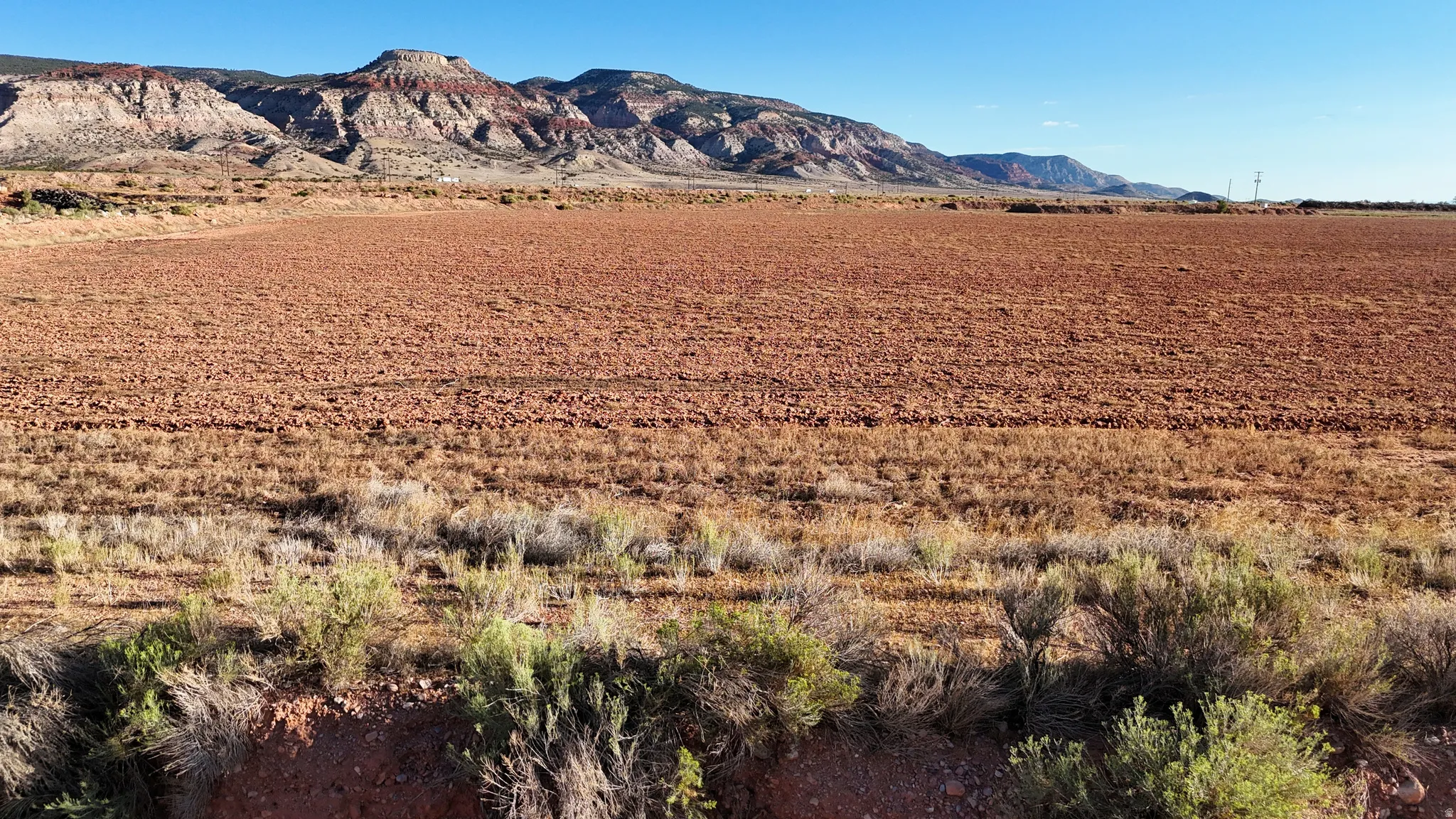 Expansive land parcel featuring cultivated earth and natural desert flora