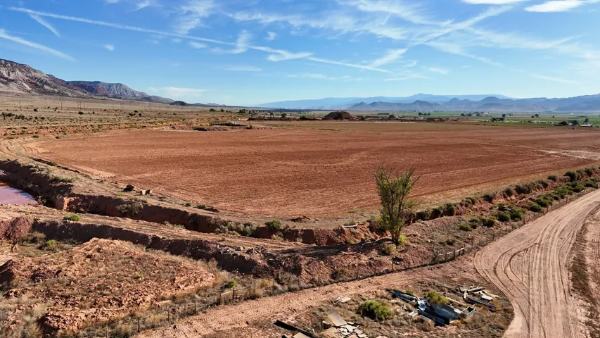 Expansive cleared land featuring a natural water basin and unpaved access roads