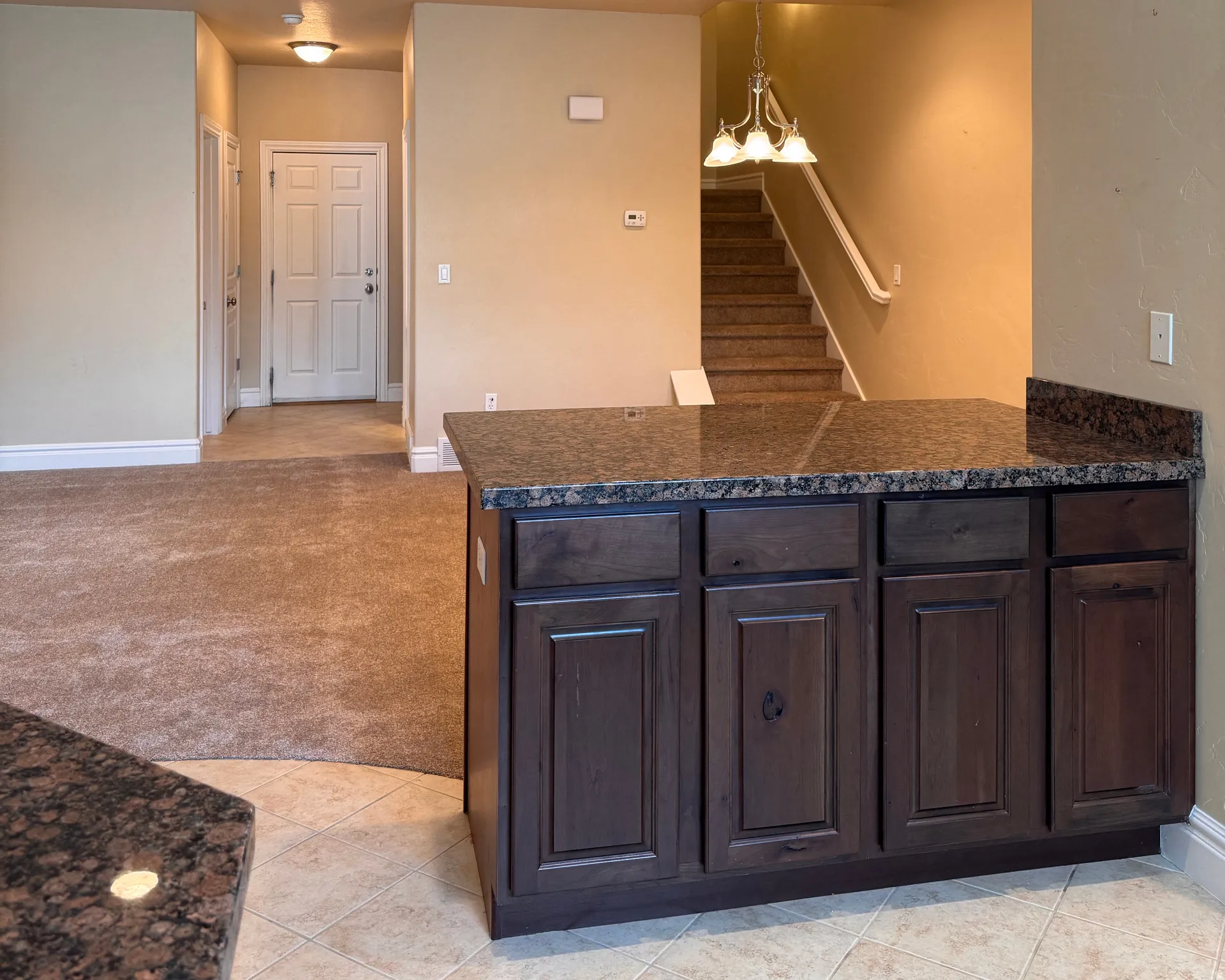 Kitchen island featuring dark wood-finish cabinetry and a stone-finish countertop