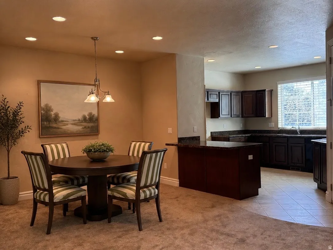 Kitchen featuring dark wood cabinetry, granite countertops, and tiled flooring