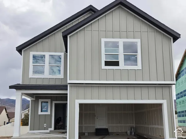 Contemporary vertical panel siding with contrasting trim, integrated two-car garage, and covered porch entry