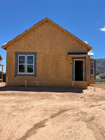 New construction framing with a gabled roofline and window openings