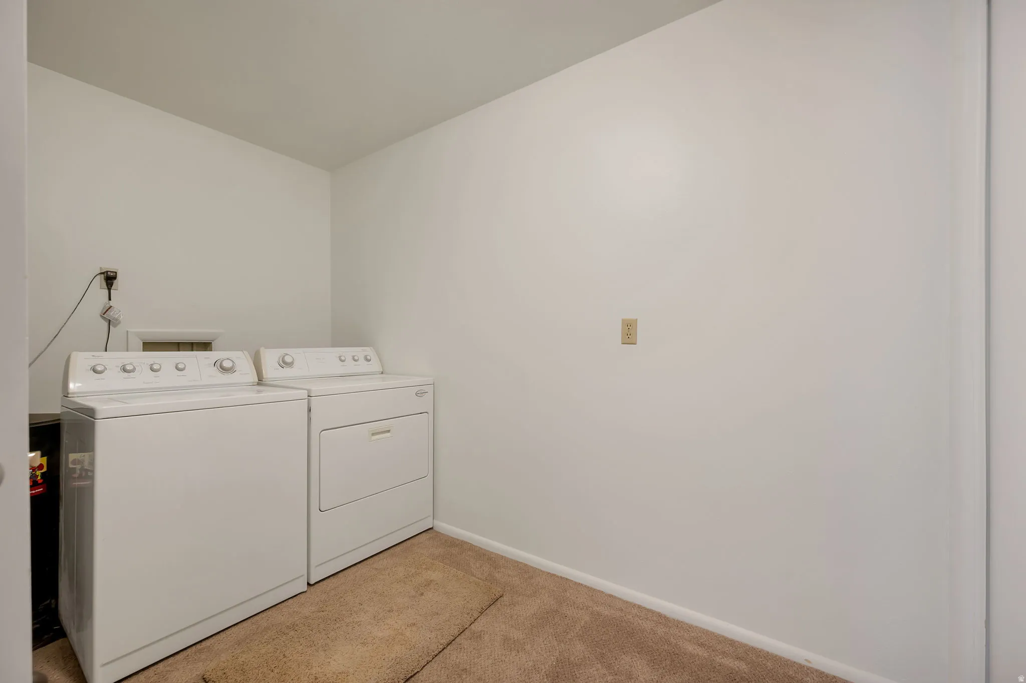 Laundry area with white appliances.