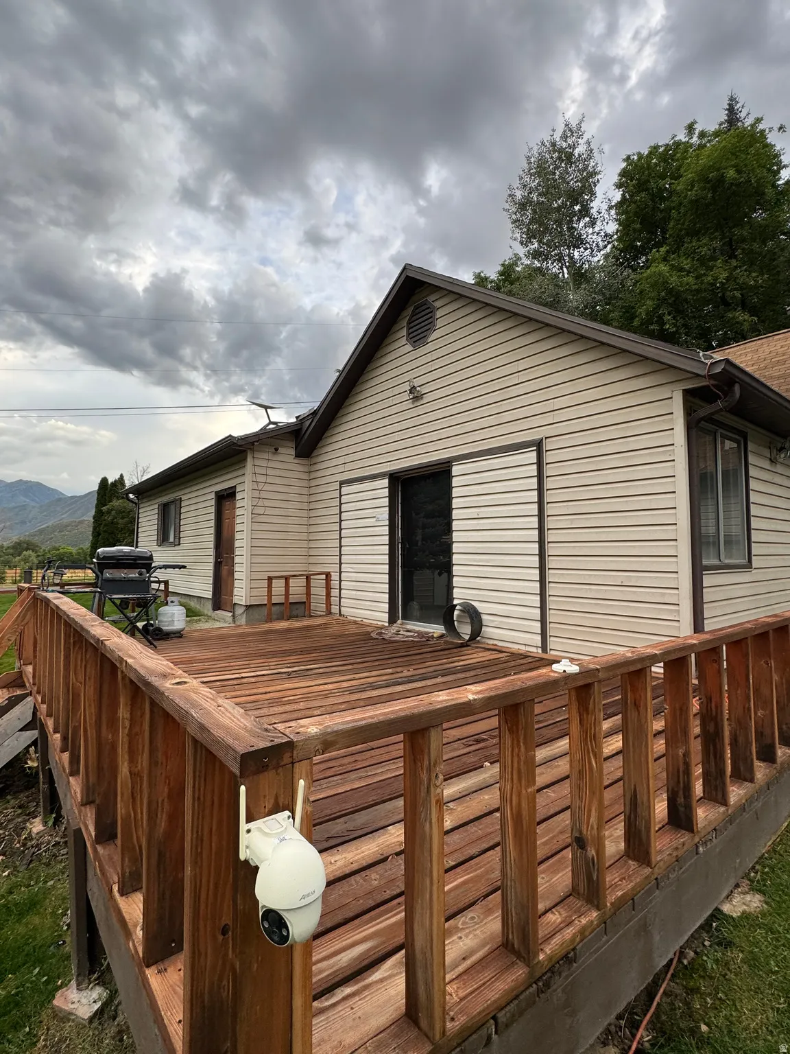 Expansive wood deck with a full railing, siding exterior, and sliding glass door access