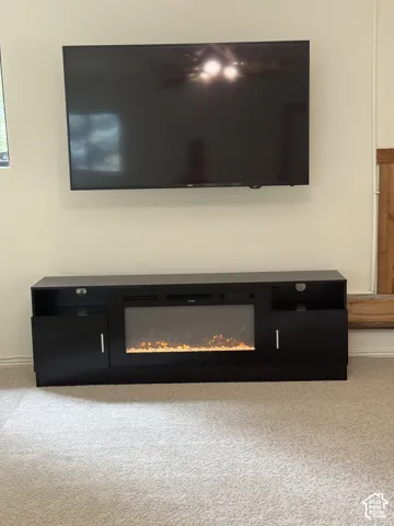 Wall-mounted television with integrated media console featuring an electric fireplace insert