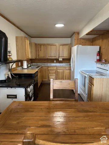 Kitchen featuring wood cabinetry, solid-surface countertops, stone-finish backsplash, and wood-finish flooring