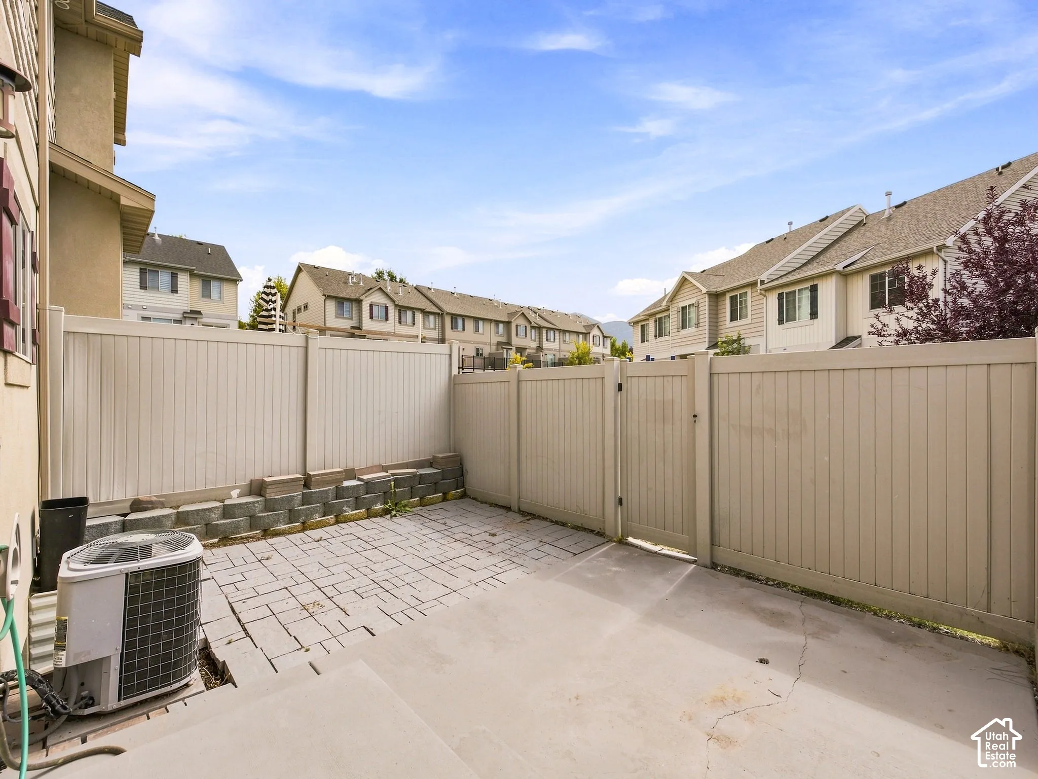 Private fenced yard featuring a concrete patio and a paver section