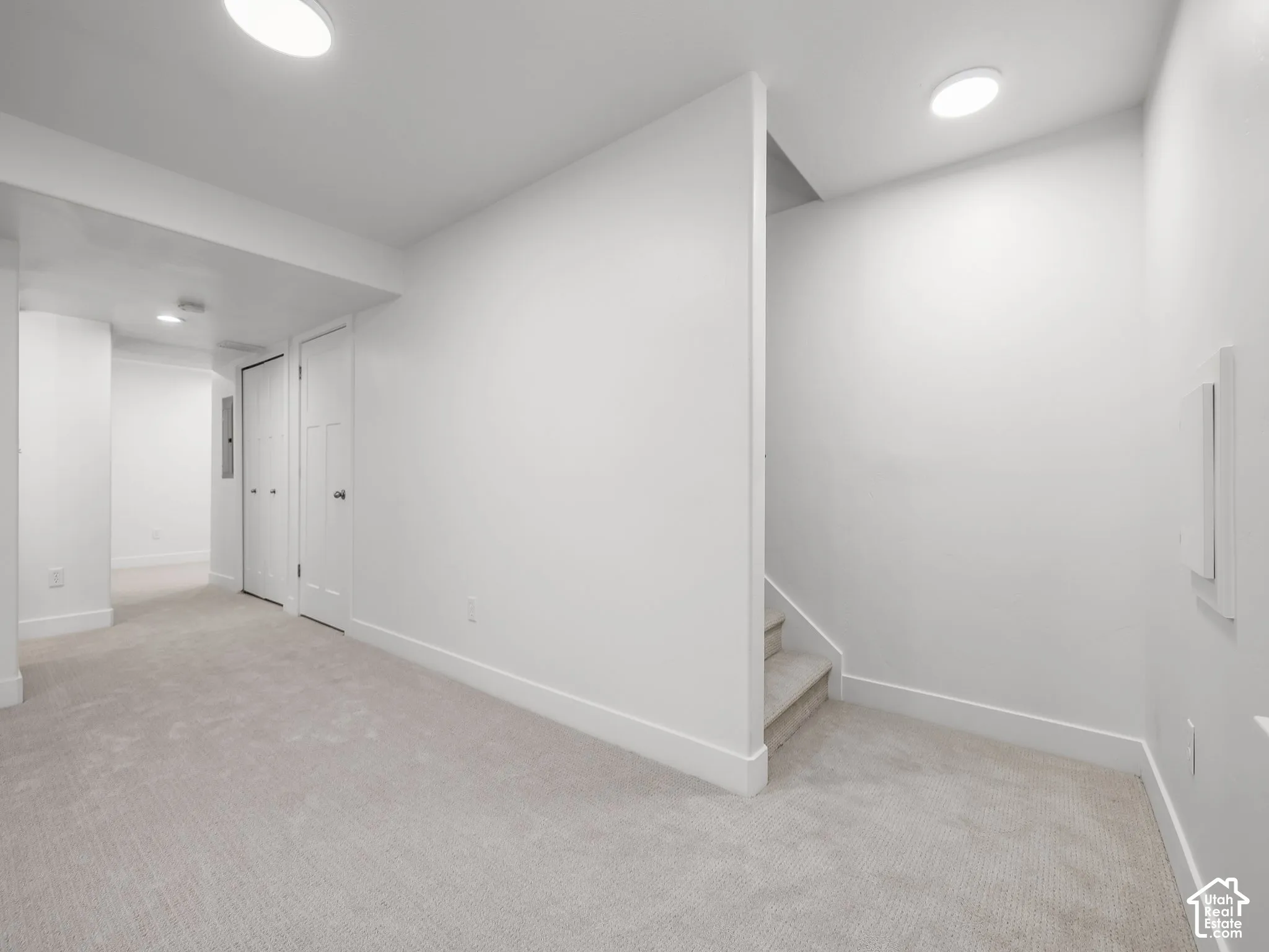 Light-colored carpeting, white baseboards, recessed lighting, and white panel doors