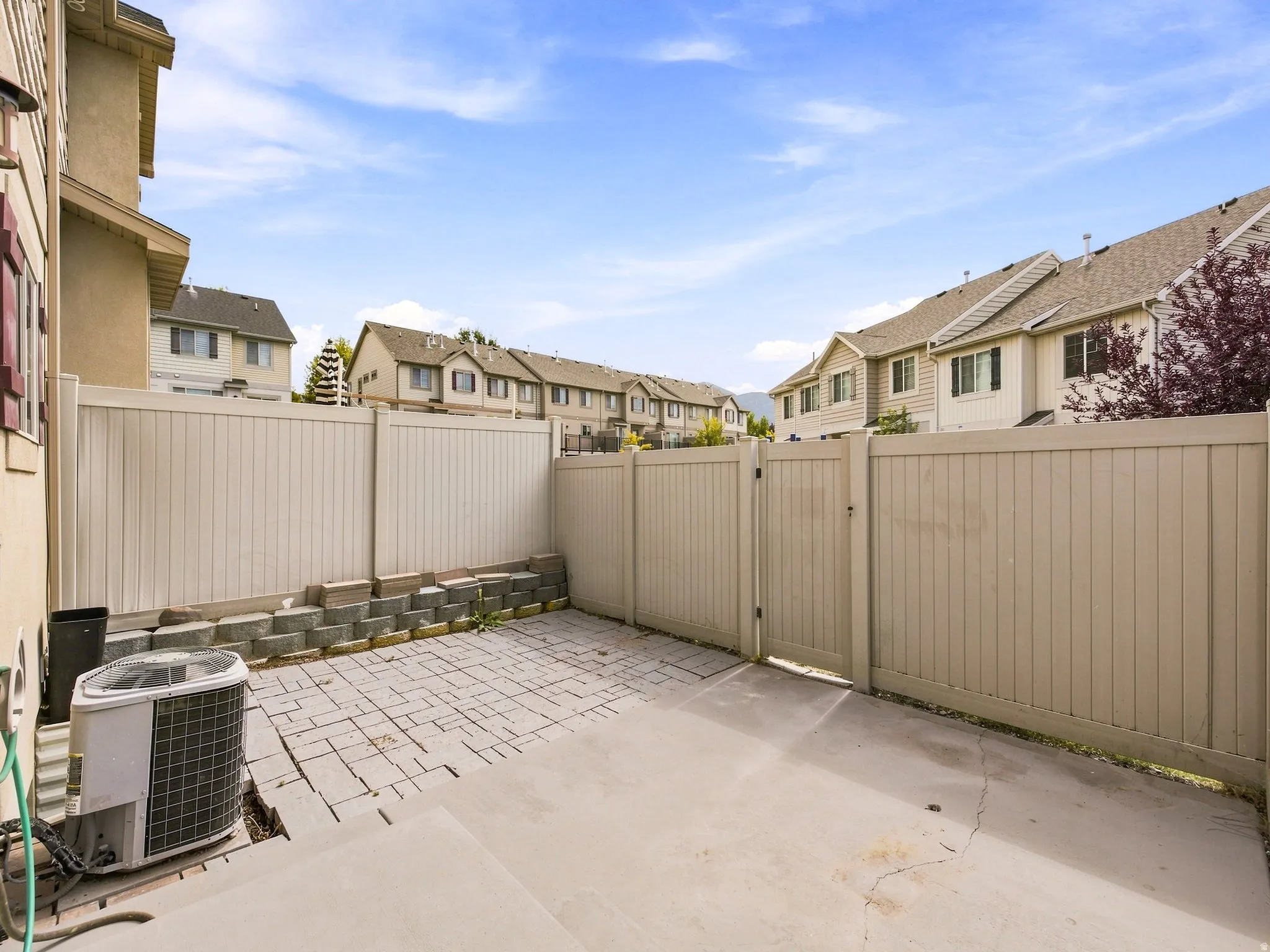 Private fenced yard featuring a concrete patio and a paver section