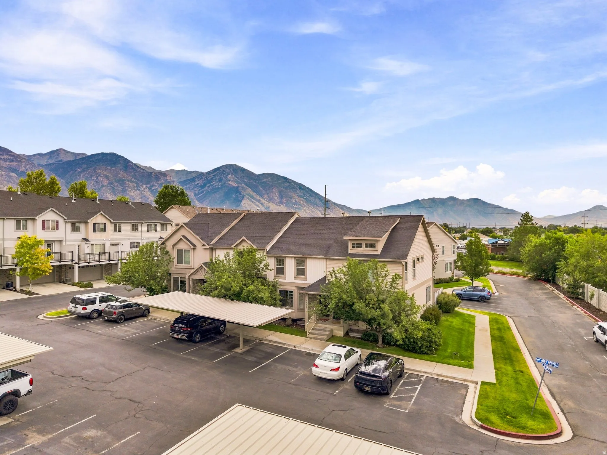 Townhome-style residences featuring dormer windows, covered parking, and landscaped grounds