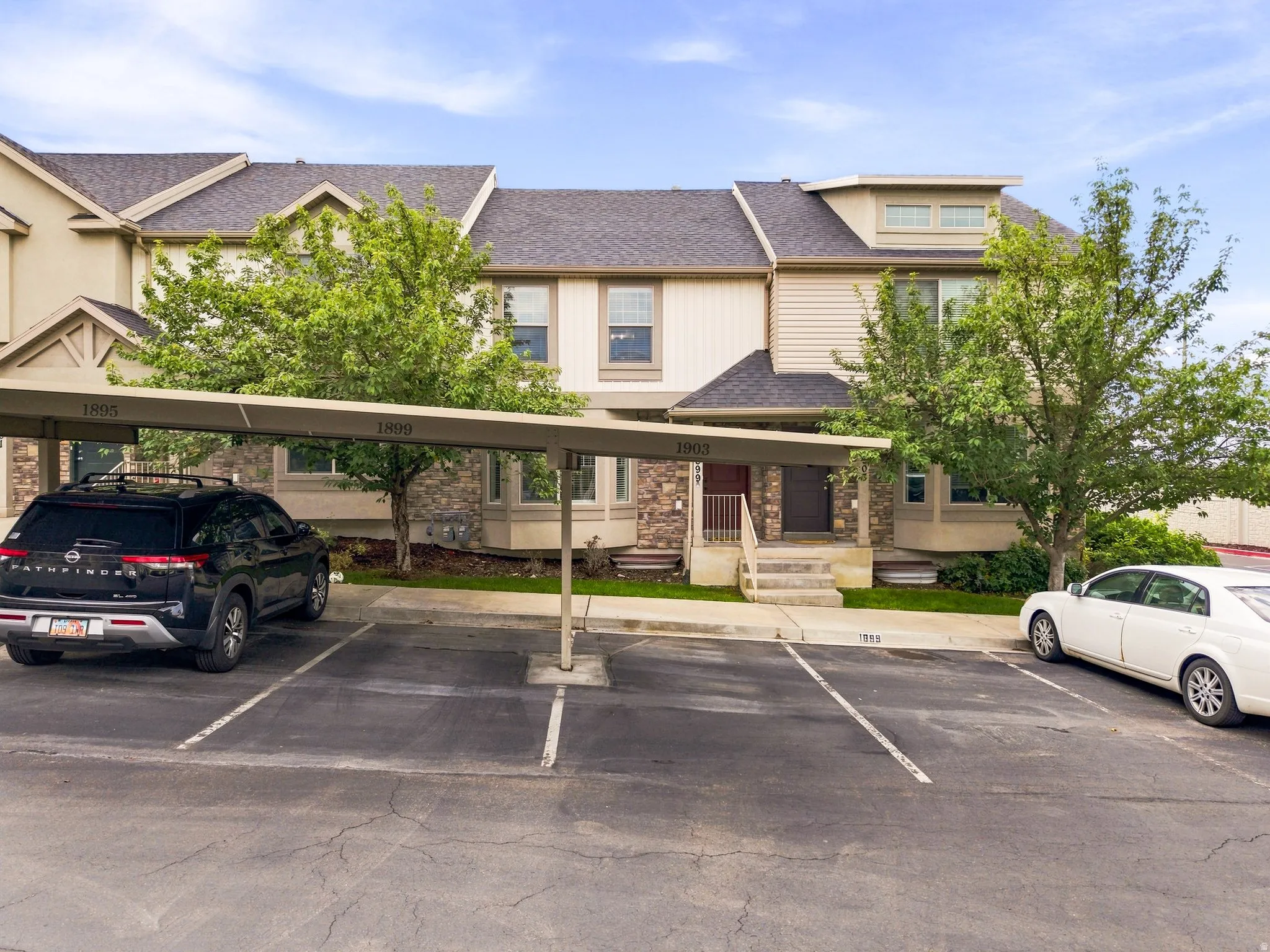 Multi-level townhome exterior with stone accents and horizontal siding