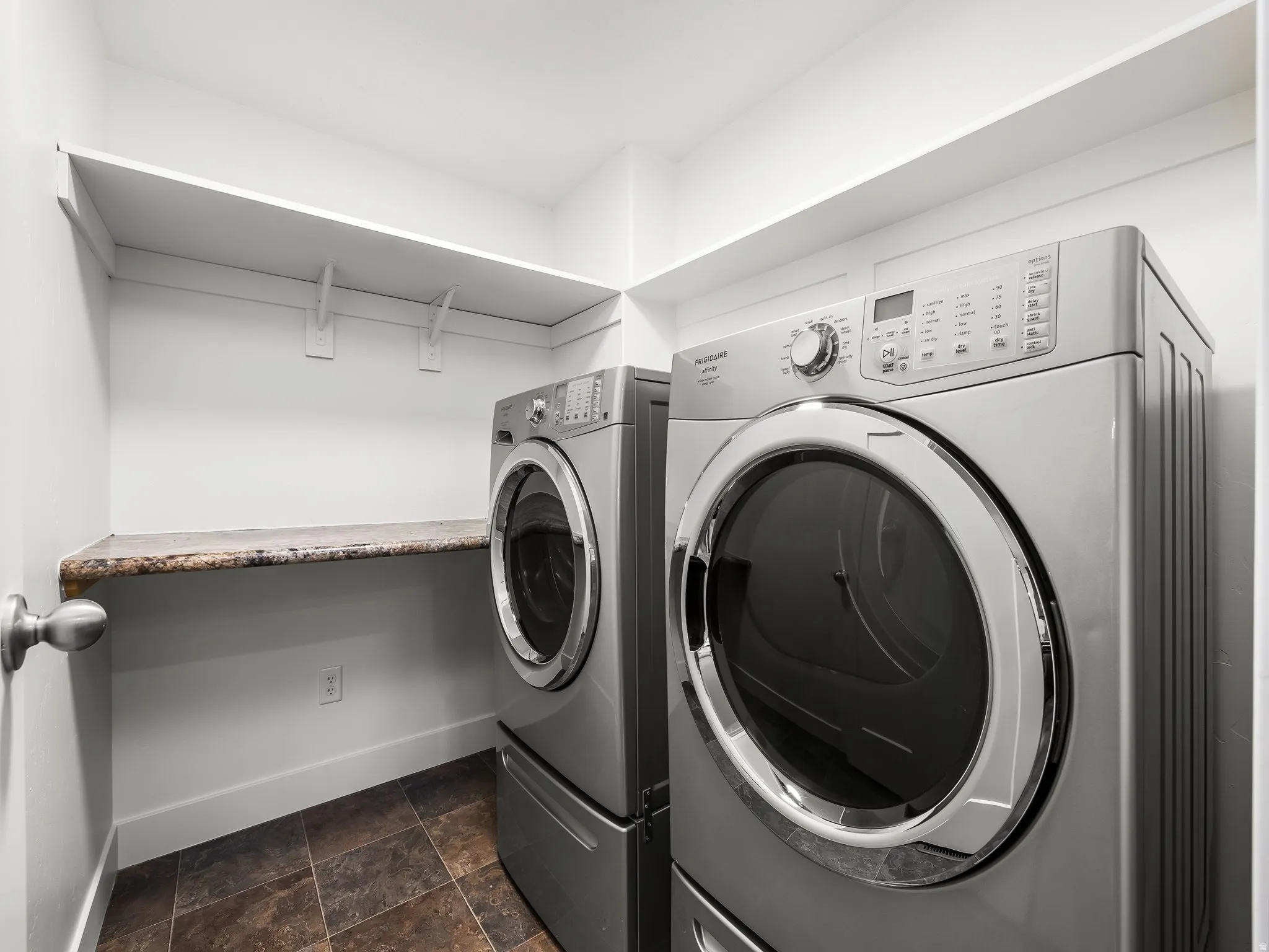 Laundry room featuring a built-in shelf, countertop space, and tiled flooring