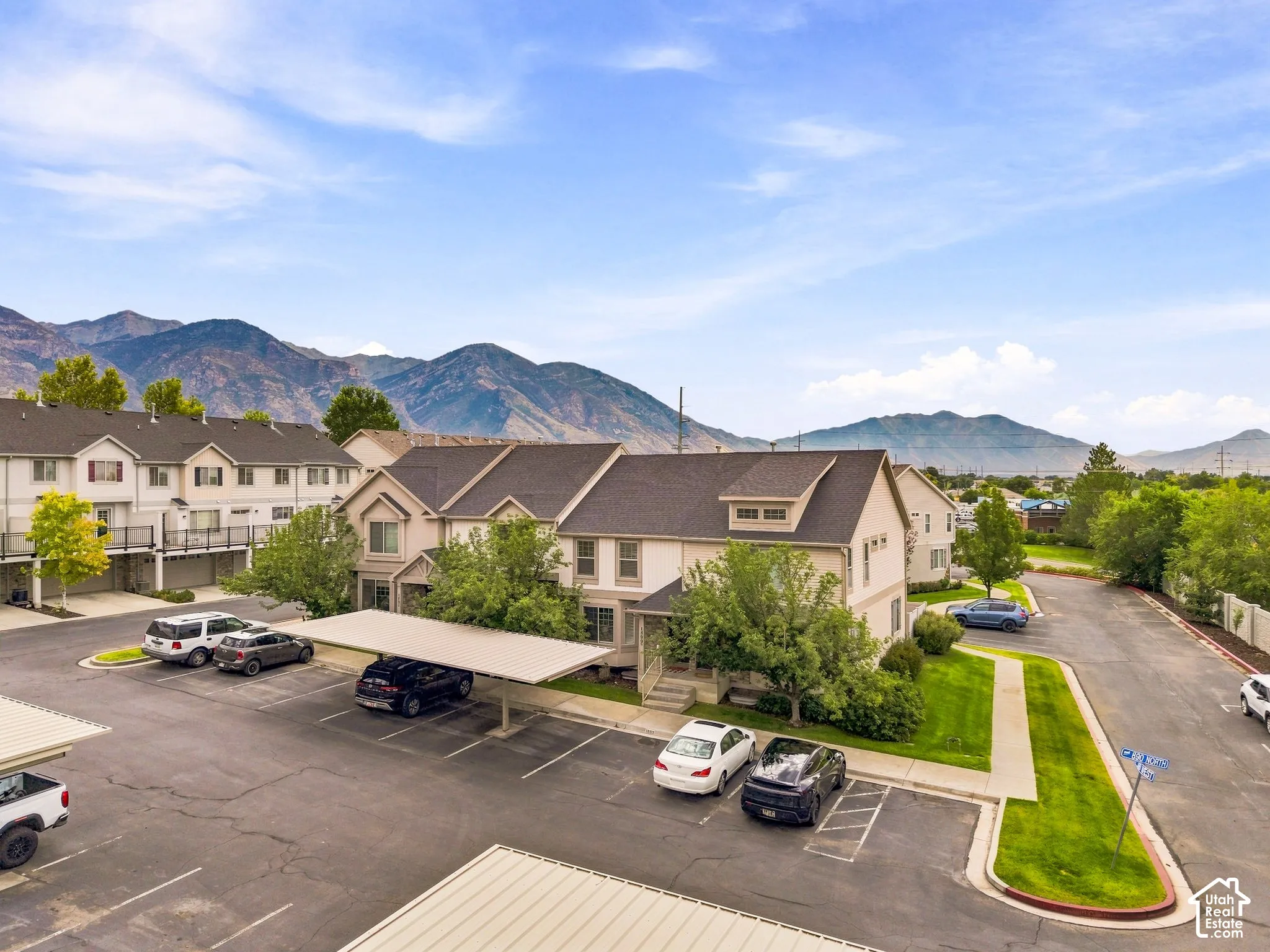 Townhome-style residences featuring dormer windows, covered parking, and landscaped grounds
