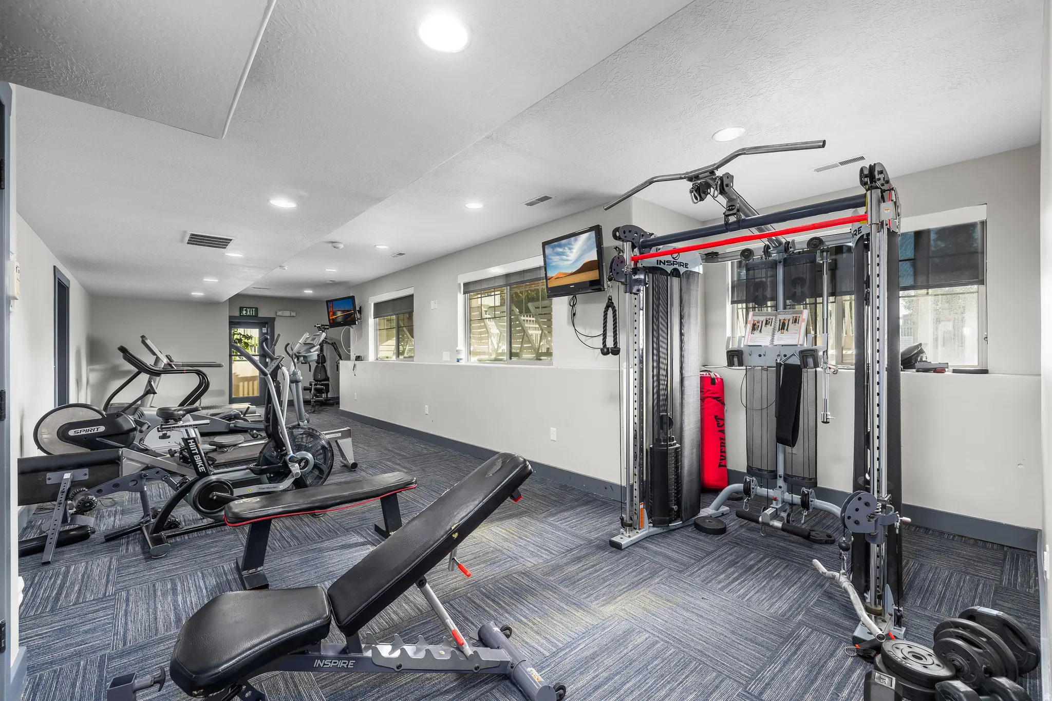 Recreational facility featuring patterned carpet flooring, recessed lighting, and a variety of exercise equipment