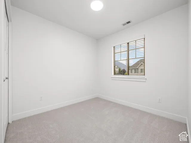 Neutral wall paint with carpeted flooring, a window with horizontal blinds, and a flush-mount ceiling light