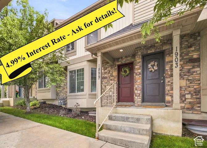 Stone facade, bay window, concrete steps, covered entry, and mature landscaping