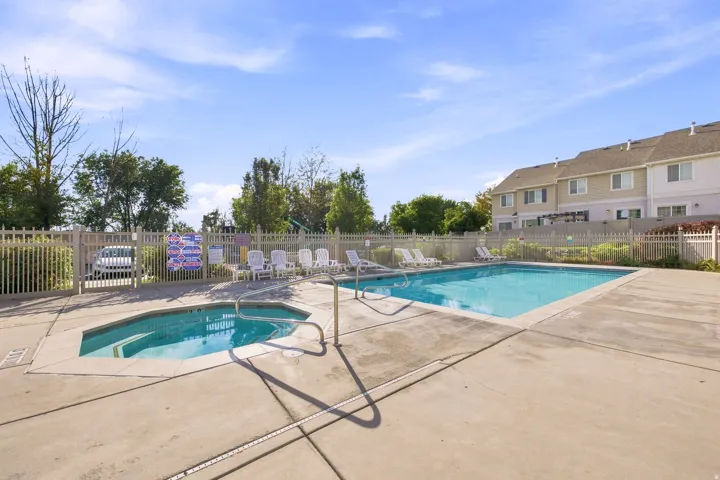 Community swimming pool and spa with concrete surround and fencing