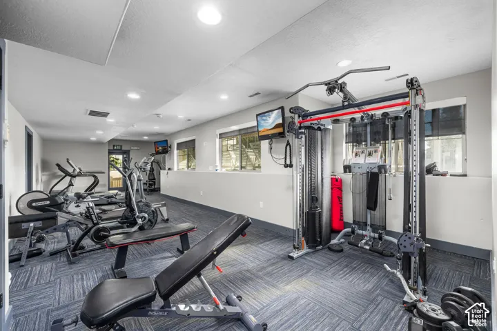 Recreational facility featuring patterned carpet flooring, recessed lighting, and a variety of exercise equipment