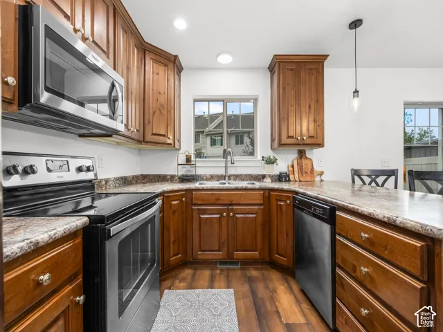 Kitchen featuring wood-finish cabinetry, stainless steel appliances, a double basin sink, and recessed lighting