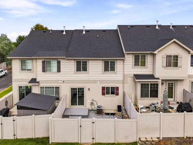 Enclosed rear patio featuring white privacy fencing, a covered storage shed, and a sliding glass door entry