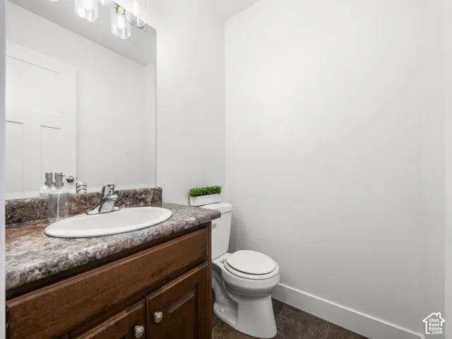 Vanity with wood-finish cabinetry, a drop-in sink, and a speckled countertop
