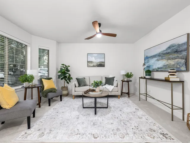 Neutral-toned carpeting, white walls, and a contemporary ceiling fan
