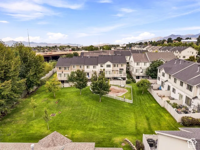Expansive green space with manicured lawn, established trees, and white picket fencing