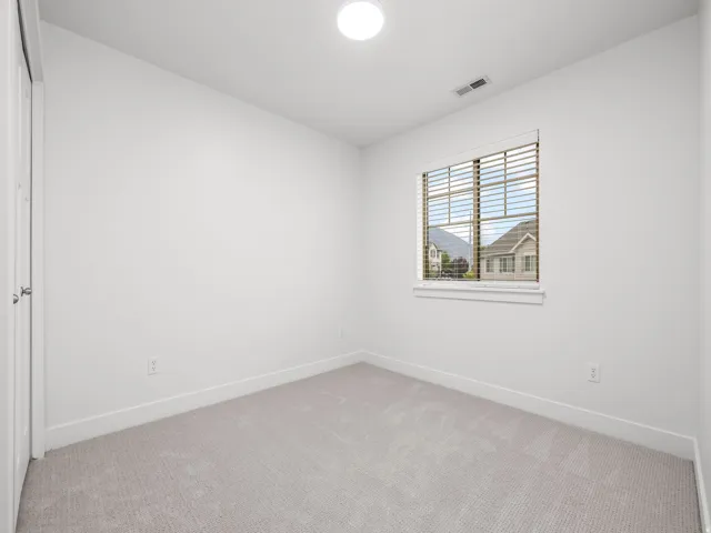 Neutral wall paint with carpeted flooring, a window with horizontal blinds, and a flush-mount ceiling light