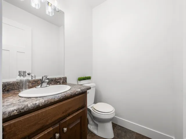 Vanity with wood-finish cabinetry, a drop-in sink, and a speckled countertop