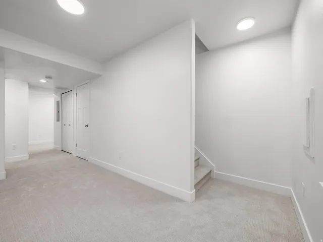 Light-colored carpeting, white baseboards, recessed lighting, and white panel doors