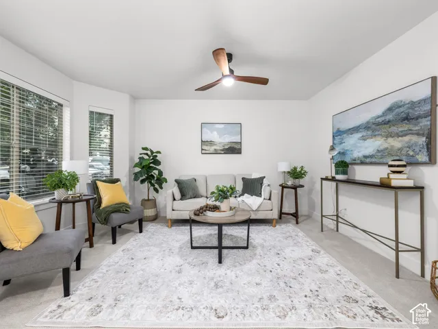Neutral-toned carpeting, white walls, and a contemporary ceiling fan