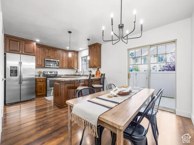 Kitchen with wood-finish flooring, stainless steel appliances, and a central island with bar seating