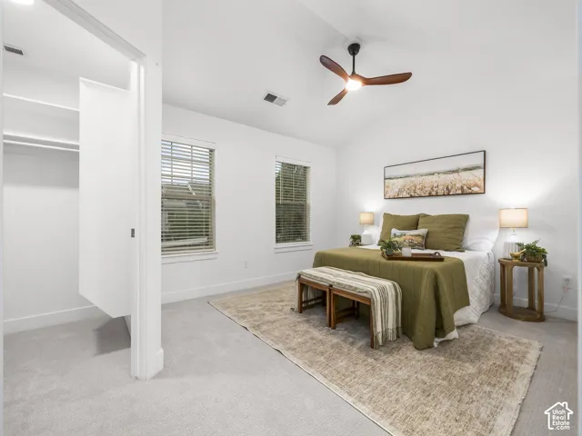 Primary bedroom with ensuite bathroom access, neutral carpeting, and abundant natural light from dual windows
