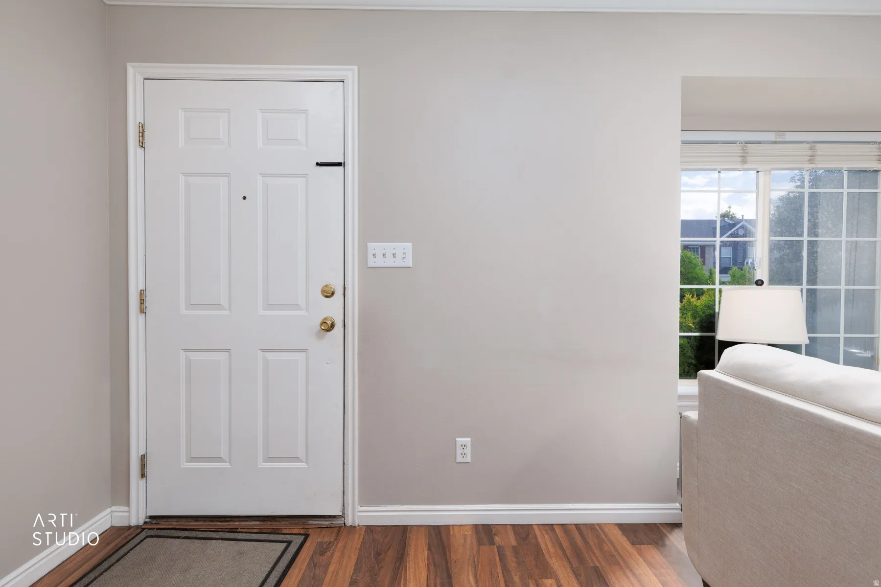 Vinyl flooring with white trim, a paneled door, and a multi-pane window