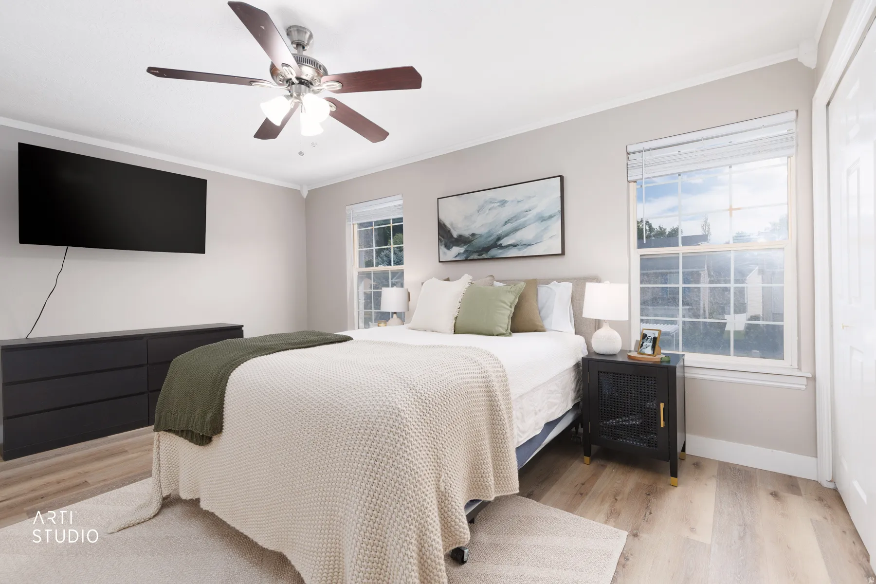 Crown molding, LVP flooring, two large windows, white trim, and a ceiling fan with integrated lighting