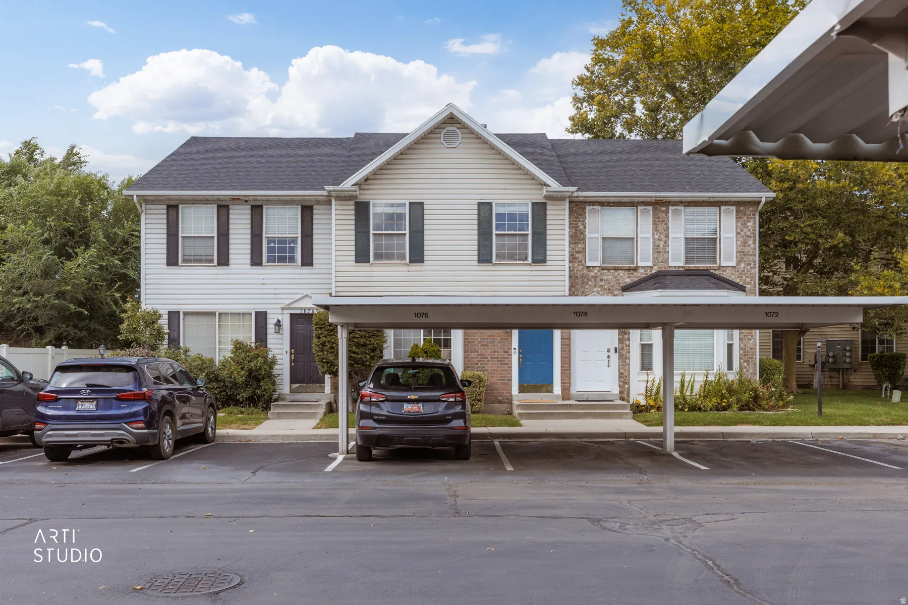 Two-story exterior with siding and brick facade, dark shingle roof, and white-framed windows with dark shutters