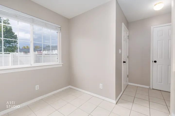 Tile flooring, neutral wall paint, white trim, multiple pane window, solid panel interior doors