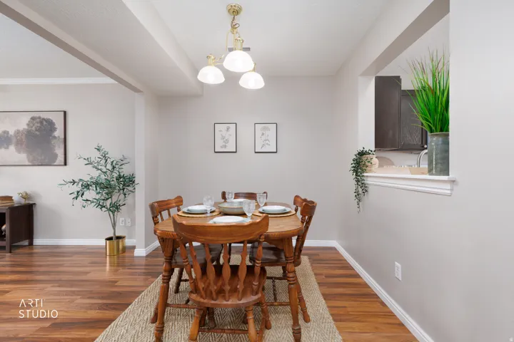 Dining area with vinyl flooring, overhead lighting, and a pass-through window with a decorative ledge