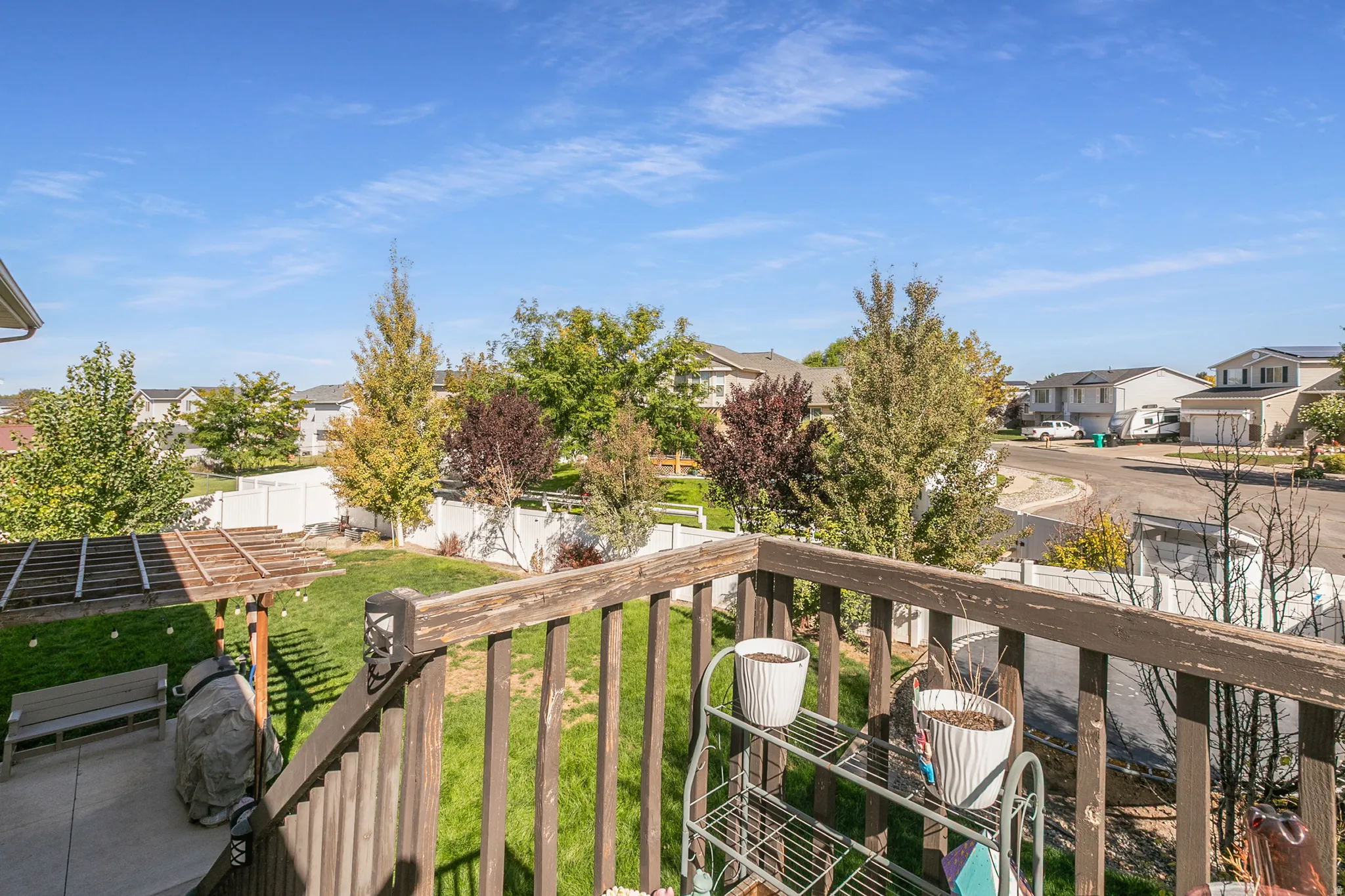 Backyard featuring a wooden pergola, concrete patio, and a manicured lawn