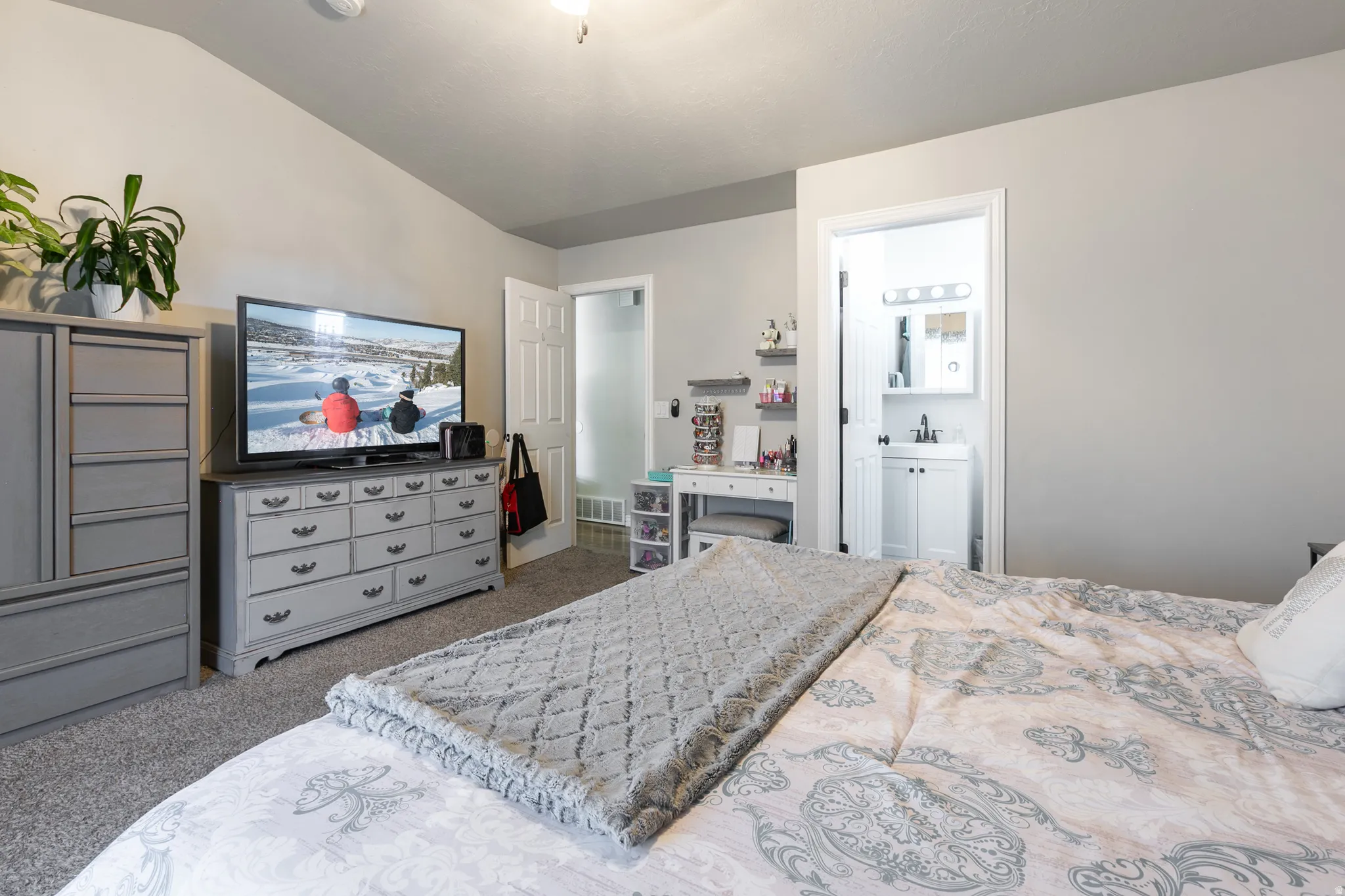 Carpeted bedroom with a vaulted ceiling