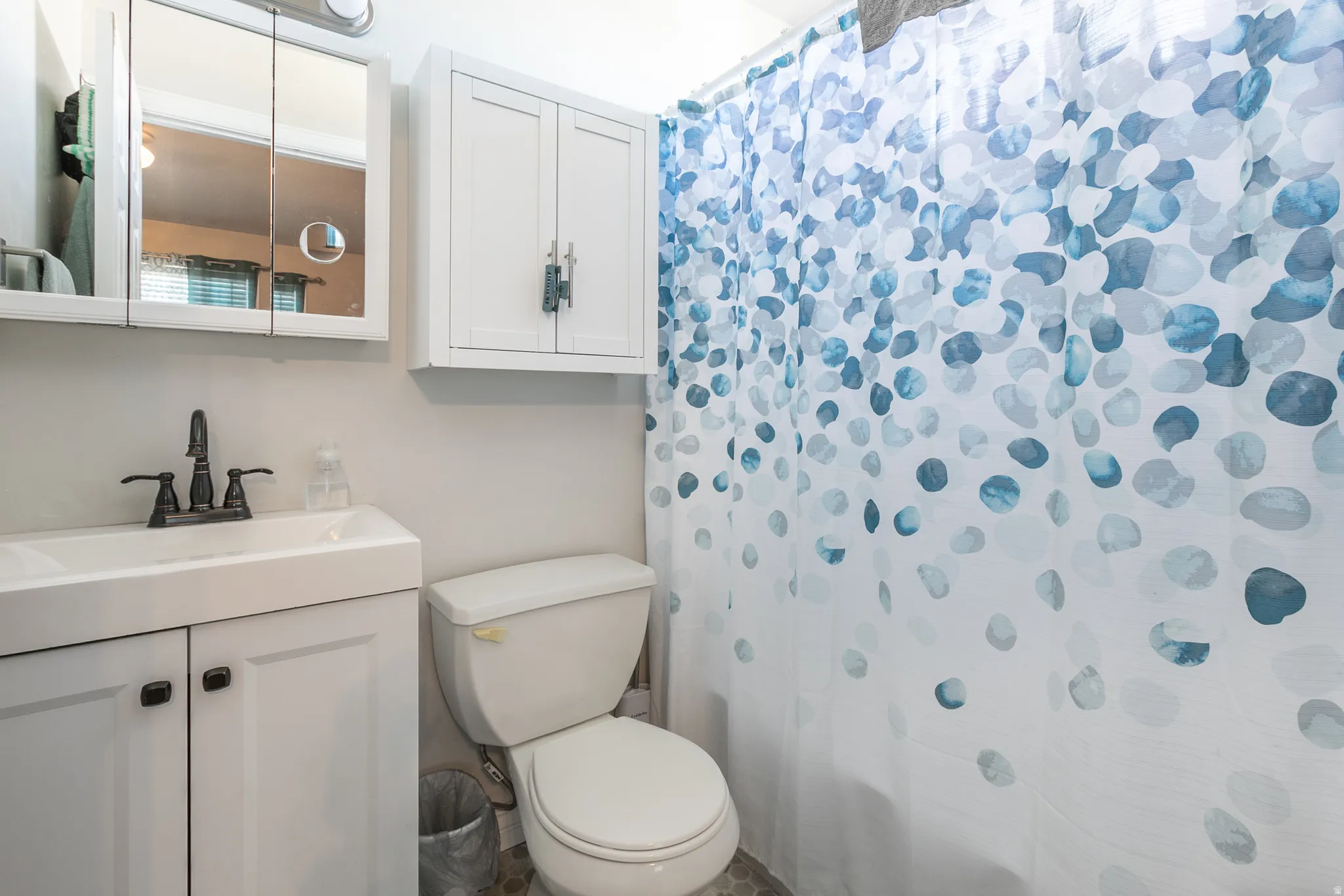 White vanity with integrated sink, matte black faucet, and coordinating hardware