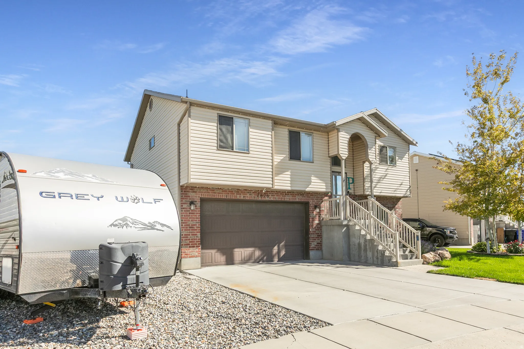 Two-story residence featuring brick and siding facade, an integrated two-car garage, and a concrete driveway