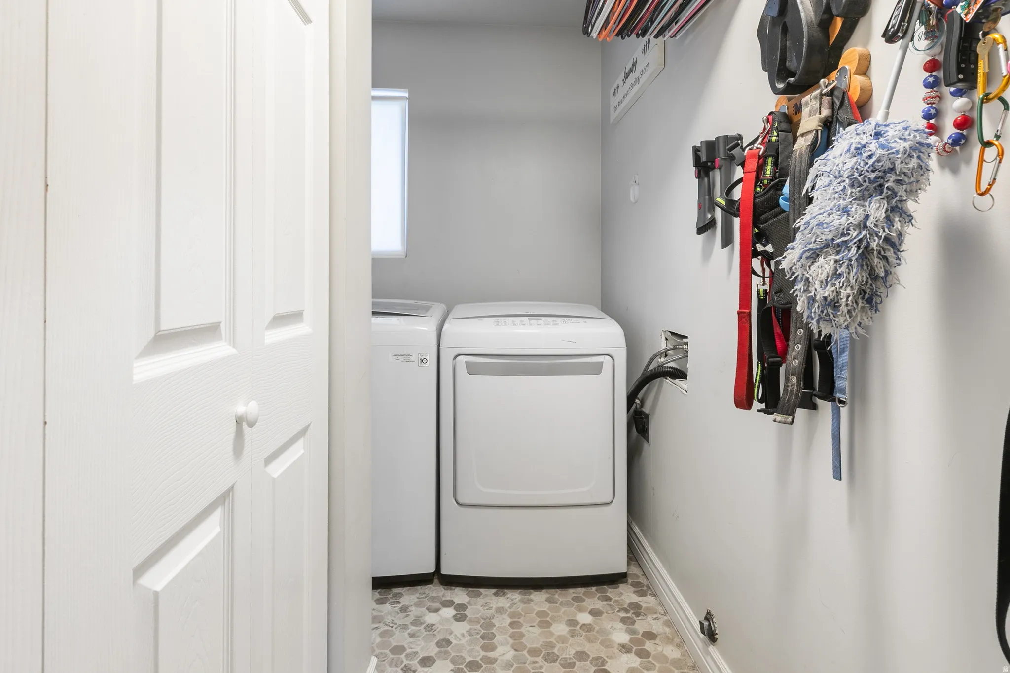 Laundry area with hexagonal floor tiles and white appliances