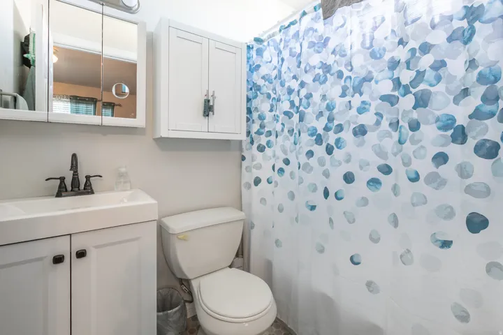 White vanity with integrated sink, matte black faucet, and coordinating hardware