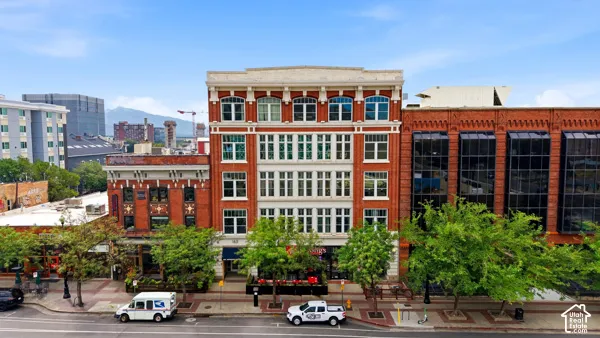 Historic brick facade with multiple large windows, ground-level retail spaces, and a detailed cornice