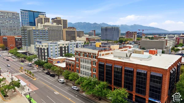 Urban landscape with a prominent commercial building featuring large windows, brick exterior, and a flat roof