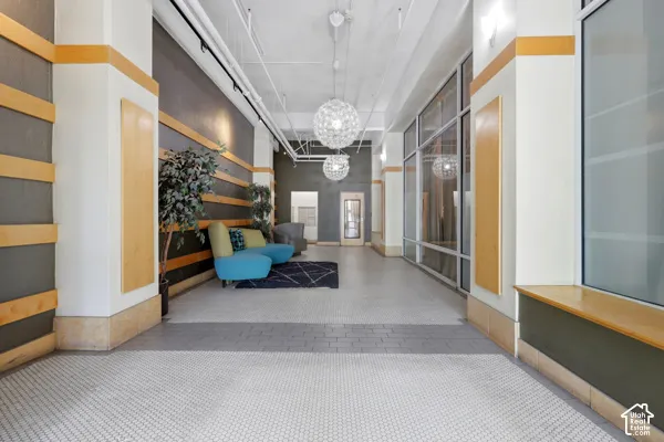 Expansive common area featuring a light-toned ceiling, hexagonal mosaic tile flooring, track lighting, and decorative pendant light fixtures